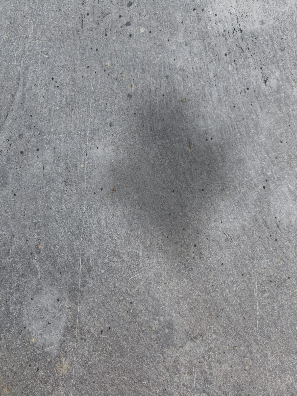 Unsealed stone darkening where water soaks in